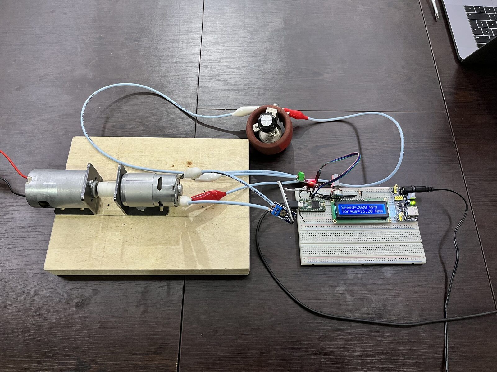 The finished dynamometer: coupled test and load motors, the potentiometer that sets the load, and the sensing electronics with an LCD.