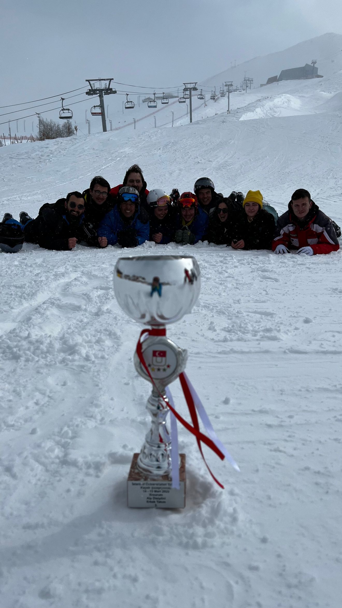 Sina with the Boğaziçi University Ski Team and one of their cups at the 2022 Turkish Universities Ski Championship.