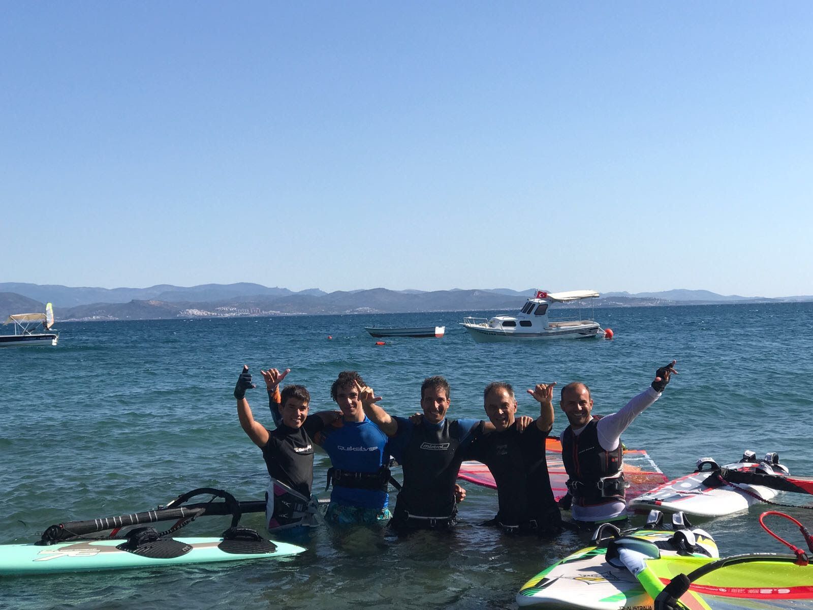 Five windsurfers standing in the sea with their boards in Güre, Balıkesir.